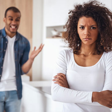 man begging for forgiveness after cheating on his wife while she stands with her back to him looking very angry