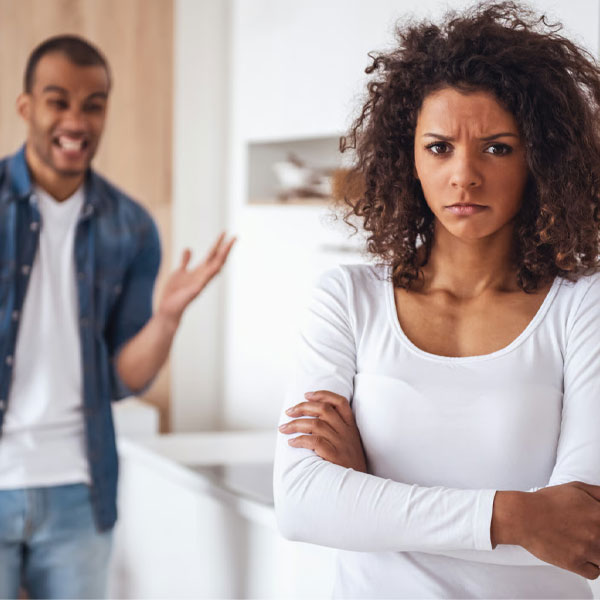 man begging for forgiveness after cheating on his wife while she stands with her back to him looking very angry