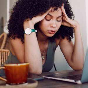woman with her hands on her temples and her eyes closed trying to block out thoughts of her husbands infidelity