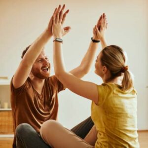 cheerful couple giving each other high five for working together as a team
