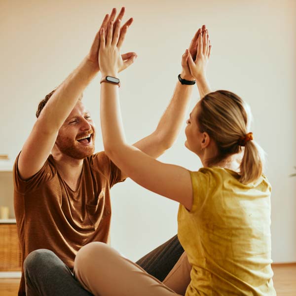 cheerful couple giving each other high five for working together as a team