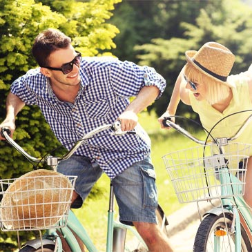 happy couple riding bikes in the park