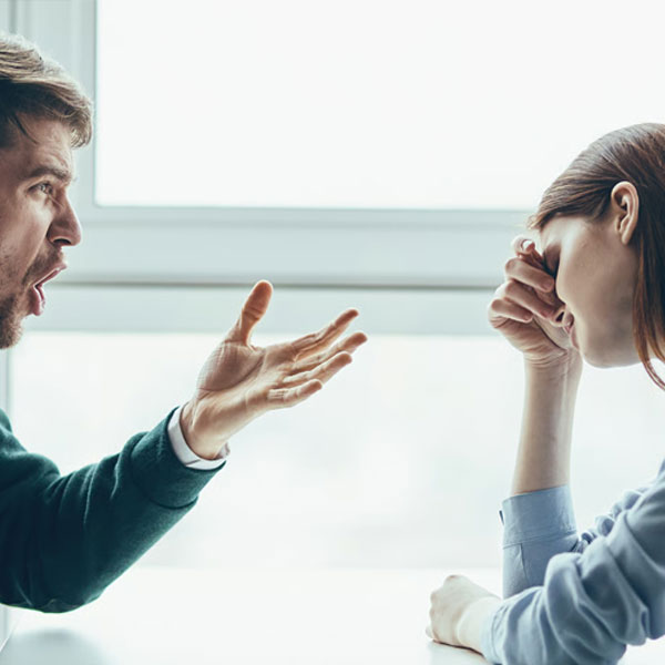 husband being verbally abusive to his wife in a cafe while wife looks overwhelmed with her emotions