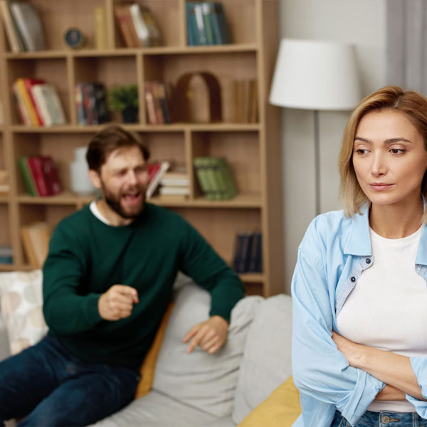 man yelling at his wife while she looks upset and sad