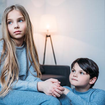two children looking anxious holding hands